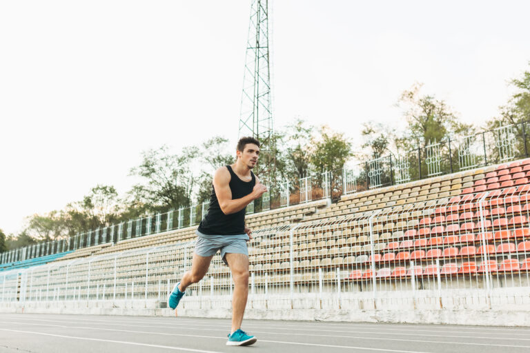 Peserta sedang berlari dalam ajang lomba lari maraton di jalan raya dengan garis finis di depan.